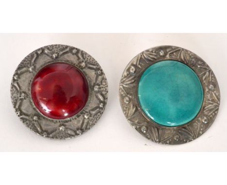 Two early 20th Century Arts and Crafts brooches each set with a Ruskin type roundel to a hammer pewter frame, the first in a 