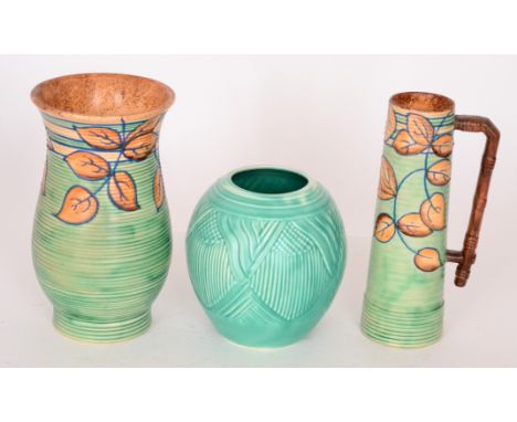 A 1930s Royal Cauldron flower jug and vase, both decorated with tubelined autumnal leaves against a green ground together wit