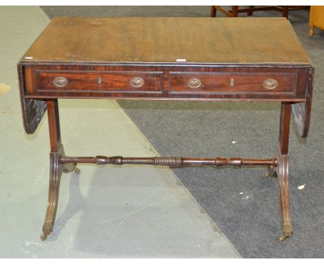 A 19th Century mahogany drop flap sofa table fitted with two frieze drawers on reeded splayed end supports united by a turned