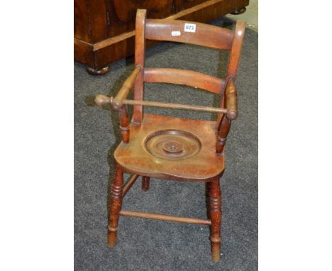 A Victorian mahogany child's commode elbow chair, the seat with a cover and front bar on turned splayed legs. 