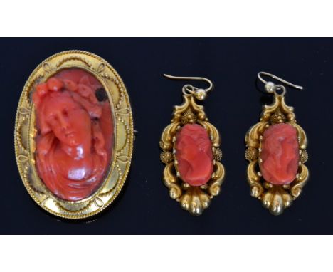 A 19th Century oval carved coral cameo head and shoulder profile of a classical maiden within a gold surround with rope twist