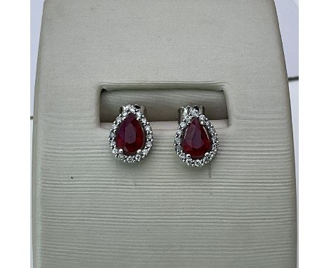 A pair of pear shaped ruby and diamond stud earrings.