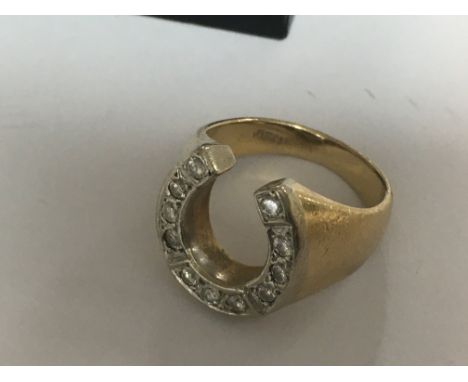 A 14 k yellow gold ring in the form of a horse shoe with diamond inset .