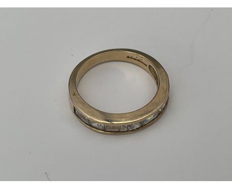 A 9ct gold ring set with a row of simulated baguette diamonds. Approx 3.3g, O.