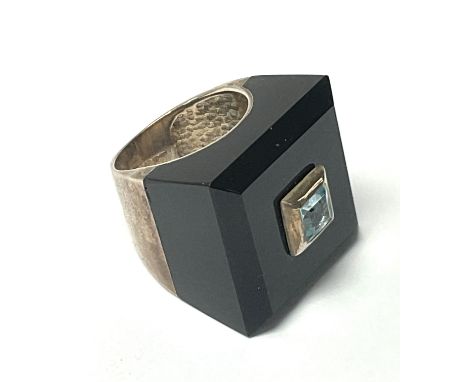 A modern design sterling silver and onyx ring inset with a square cut blue topaz. K.