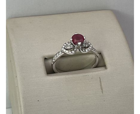 An 18ct Ruby solitaire surmount h by diamond set shoulders. M.