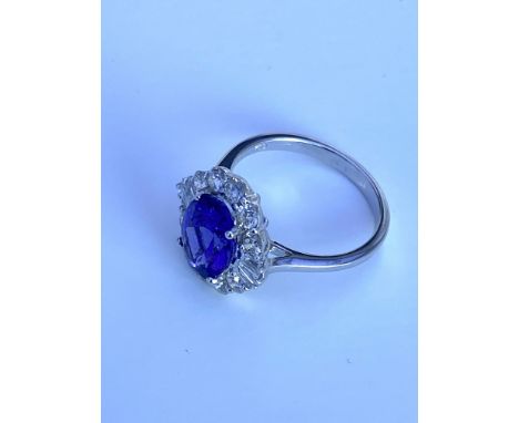 An 18ct white gold ring set with a natural oval 3.12ct tanzanite and surround by approximately 0.99ct of brilliant and baguet