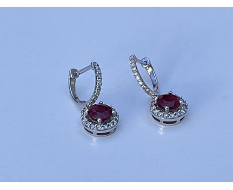 A pair of white ruby and diamond halo design drop earrings