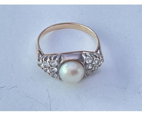 An unmarked yellow metal ring set with a Pearl and small stones CZ. Approx 3g. Ring size approx N.