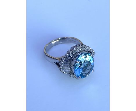 A large platinum dress ring set with a good quality oval 5.05ct aquamarine and surrounded by baguette and RBC diamonds. (N).