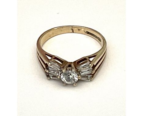 A 9ct gold ring set with a central white stone flanked by white cut baguette stones. Approx 2.3g, J.