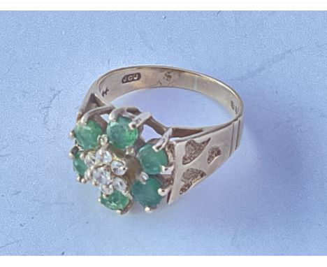 A 9ct gold ring set with a pattern of emeralds and small diamond flower shape. Approx 3g. Ring size approx K.