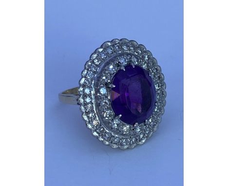 A large 18ct gold dress ring set with a large central amethyst and 2 graduating rows of cut diamonds. (L).