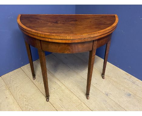 Regency satinwood crossbanded mahogany half round fold over card/tea table on inlaid tapered legs to casters 92 cm diam/wide 
