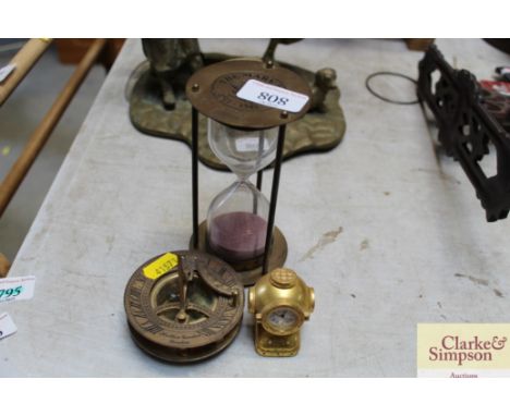 A reproduction brass compass; brass timer and a small brass clock