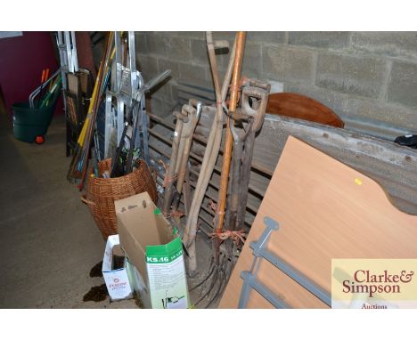 A quantity of long handled garden tools include forks; scythe; spades; two pitch forks; box containing shears and oil cans