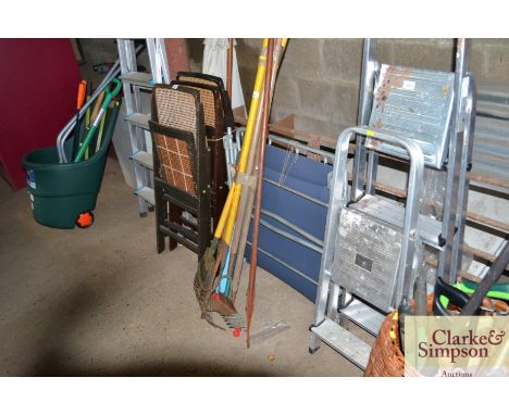 A quantity of long handled garden tools and a folding garden lounger 