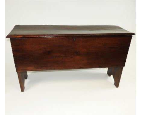 An oak six plank chest, 18th century and later, the bevelled rectangular top above a plain front with notched corners, the de