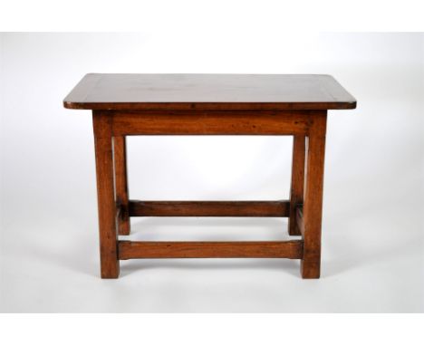 A small early 20th century mahogany side table in the Arts and Crafts style, the rounded rectangular top raised on shamford s