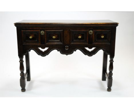 A small stained oak dresser base / side-table in the Jacobean manner, with a pair of drawers with twin brass handles and circ