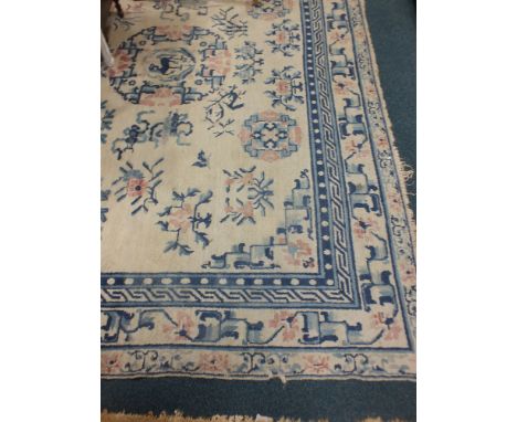 A Chinese carpet circa 1950, the ivory field centred by a roundel surrounded by floral springer tabist motifs enclosed by sty