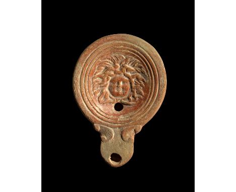 Tonlampe mit Gorgoneion. Römisch, östliches Mittelmeergebiet, 1. Jh. n.Chr. Loeschcke Typ IV, Schulter V. L 10,5cm, H 3cm. Au