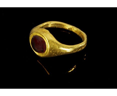 Goldener Ring mit Granat. Römisch, 2. Jh. n.Chr. 5,18g, Ringgröße 54. Schmale, nach oben breiter werdende Schiene, auf der Pl