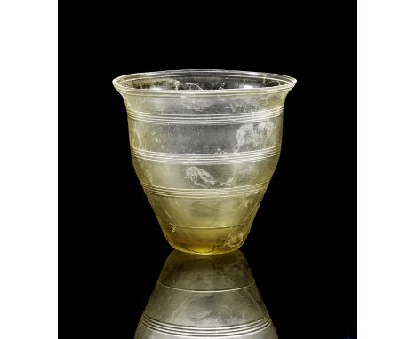 Gravierter Becher. Östlicher Mittelmeerraum, 1. Jh. n. Chr. H 8,9cm. Aus hellgrünem Klarglas. Konischer Körper mit kleinem ge