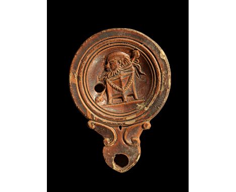 Tonlampe mit Satyrmaske. Römisch, 1. Jh. n.Chr. Loeschcke Typ IV, Schulter Typ IIIa. L 10,9cm, H 2,6cm. Aus beigem Ton mit ro