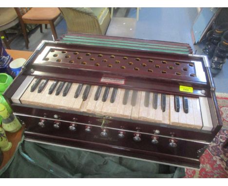 A special model laying style harmonium with a canvas carry case 