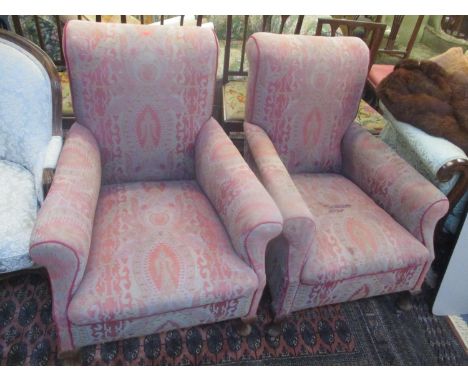 A pair of Edwardian upholstered armchairs on short cabriole front legs and ceramic castorsLocation: FR 