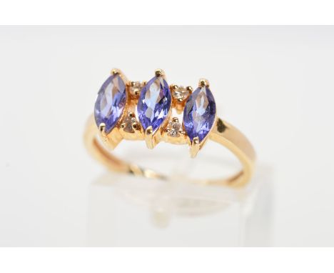 A TANZANITE AND DIAMOND DRESS RING, designed as a line of three marquise shape tanzanites each interspaced by two claw set br