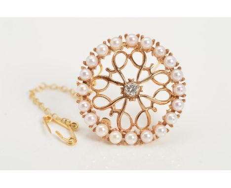 A 14CT DIAMOND AND SEED PEARL BROOCH, of circular openwork scrolling design, centrally set with a brilliant cut diamond to th