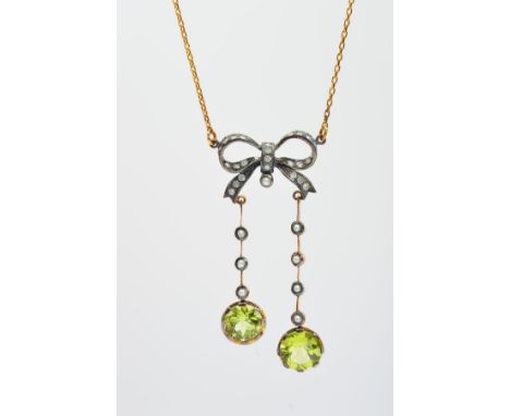 A DIAMOND, SPLIT PEARL AND PERIDOT NECKLACE, the pendant section designed as a diamond set bow suspending two graduated lines