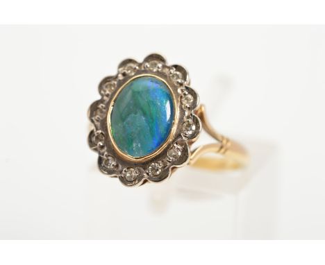 A 9CT GOLD OPAL AND DIAMOND CLUSTER RING, the central oval opal triplet within a scalloped surround set with twelve single cu