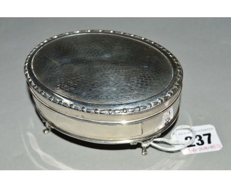 A GEORGE V OVAL SILVER TRINKET BOX, engine turned hinged cover, red velvet lined interior, on four scrolled cabriole legs, ov