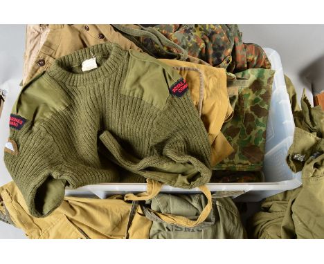 A LARGE PLASTIC STORAGE BIN CONTAINING VARIOUS ITEMS OF GENUINE MILITARY UNIFORM, to include jackets, trousers, smocks, shirt