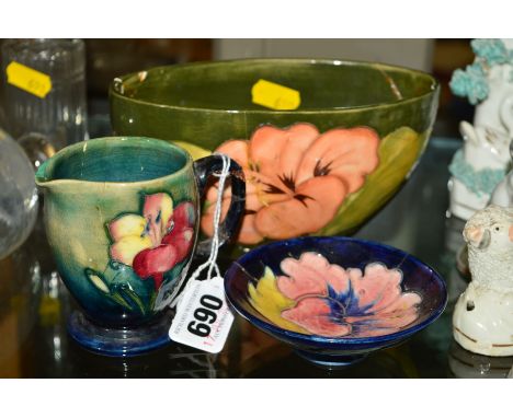 THREE PIECES OF DISTRESSED MOORCROFT POTTERY to include footed jug, a footed trinket dish, 'Hibiscus' on blue ground and oval