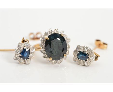 A 9CT GOLD SAPPHIRE AND DIAMOND CLUSTER RING WITH A PAIR OF SIMILAR DROP EARRINGS, the ring with a central oval sapphire with
