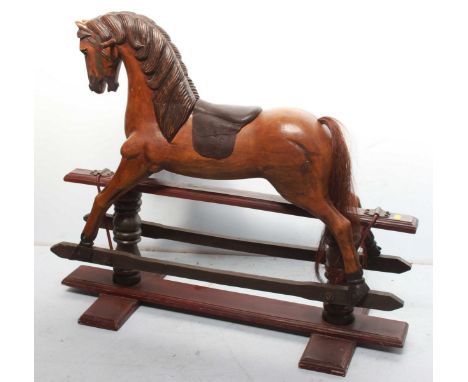 A carved and painted child's rocking horse on swinging cradle, with leather saddle.  (Stirrups require re-fixing)  105cm high