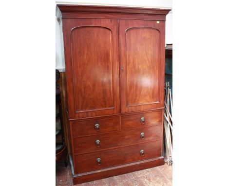 A George III mahogany linen press, with a pair of panel doors enclosing four slides, upon a base of two short and two long gr