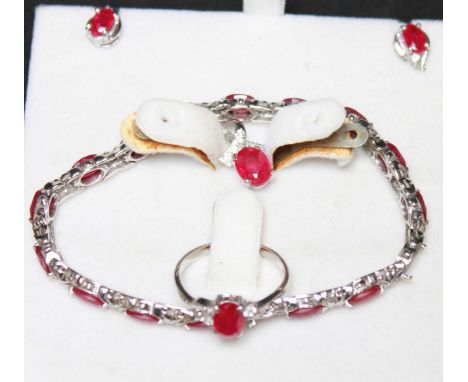 An 18ct white gold, ruby and diamond suite of jewellery, comprising a bracelet set with fifteen oval rubies (should be 16 but