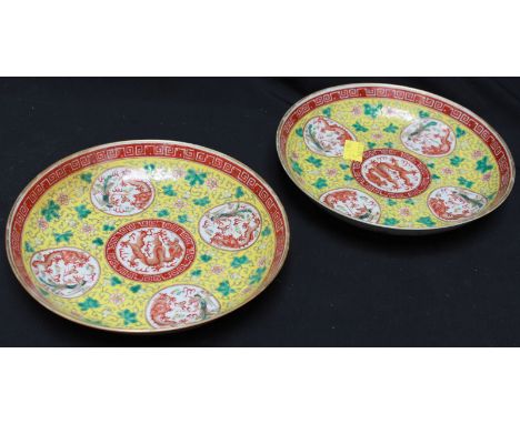 A pair of late 19th century Chinese Kuang -hsû polychrome famille jaune circular deep plates, decorated with central roundels