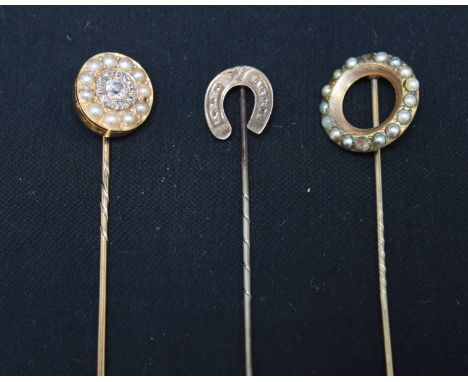 A gold, diamond and seed pearl tie pin; a gilt metal roundel tie pin and a horse shoe tie pin (3).