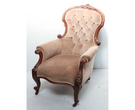 A Victorian carved mahogany button back library chair, with carved show wood frame, padded back, seat and arms, and supported