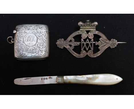 A silver and mother of pearl fruit knife; an engraved silver vesta case and a silver brooch (3).