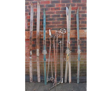A collection of vintage wooden skis and ski boots.