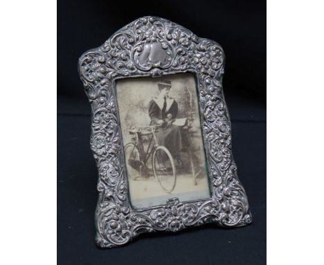 A late Victorian silver embossed photograph frame, hallmarked Birmingham 1901, decorated with elaborate scrolls and flowers, 