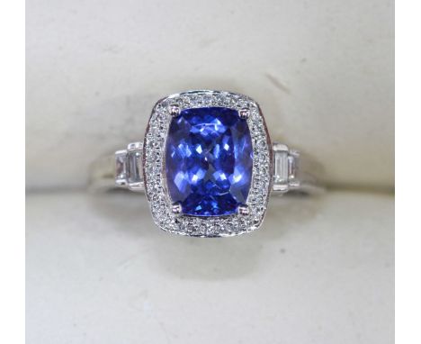 An 18ct white gold, Tanzanite and diamond ring, centrally claw-set with a rectangular cushion-cut tanzanite, approximate weig