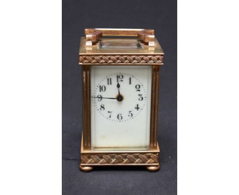 A 19th century brass carriage clock, with white enamel dial and Arabic numerals, the case with reeded edges and basket weave 